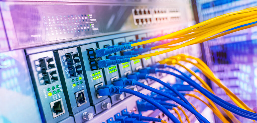 Blue and yellow cables plugged into a computer server, used on the page for Fibre optic cabling services: installation, repair and termination.